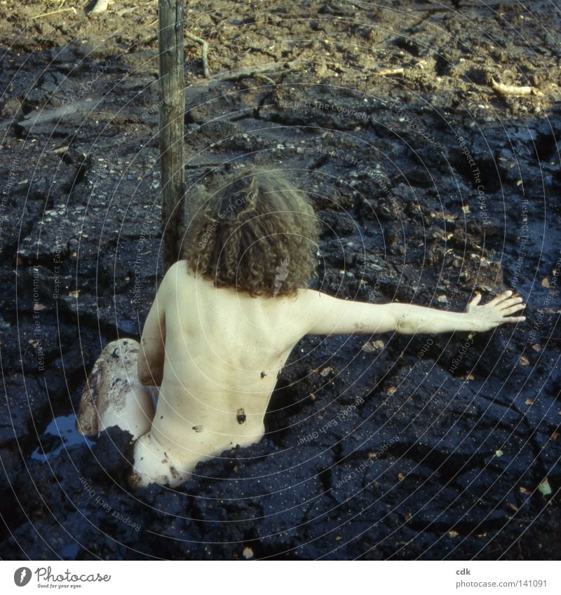 Mud Performance | Mess Woman Torso Shoulder Spinal column Thigh Waist Hand Naked Dark Mud bath Bog Surface Wood Sunbeam Square Seasons Senses Connectedness