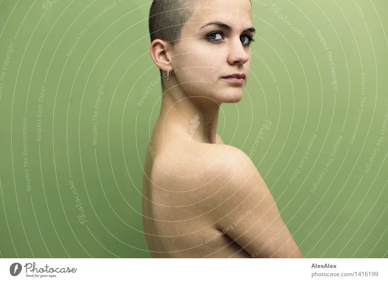 Young woman with bald/very short hair stands naked on side in front of light green wall Youth (Young adults) Face Shoulder 18 - 30 years Adults Brunette