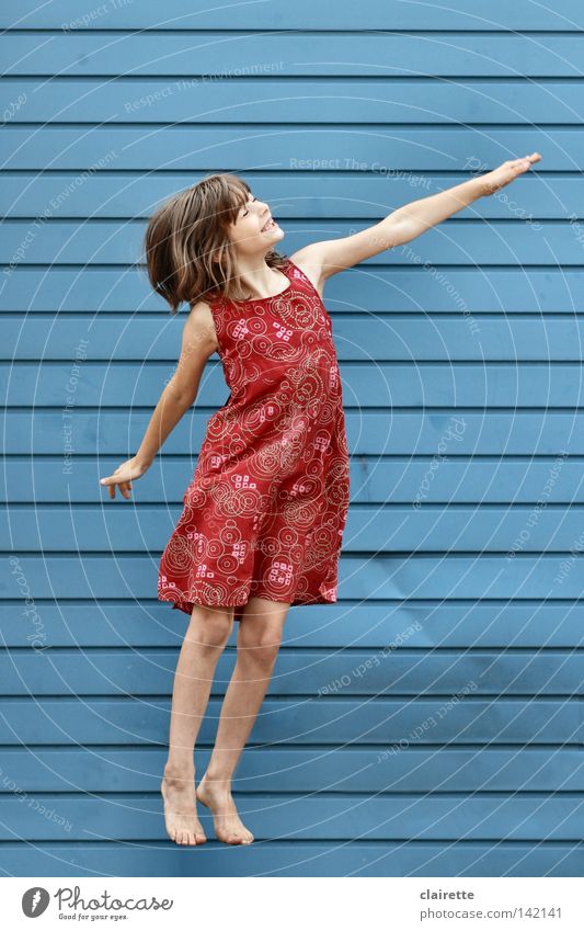 Supergirl takes off Colour photo Multicoloured Exterior shot Full-length Half-profile Closed eyes Joy Child Girl Dress Flying Jump Blue Red Floating Superman