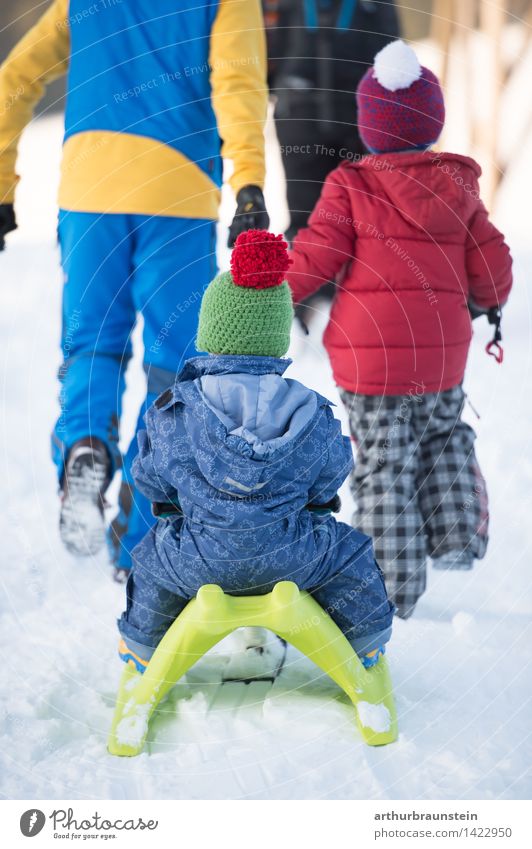 Young family goes sledging in the snowy landscape in winter Joy Leisure and hobbies Sleigh Vacation & Travel Tourism Trip Winter Snow Winter vacation