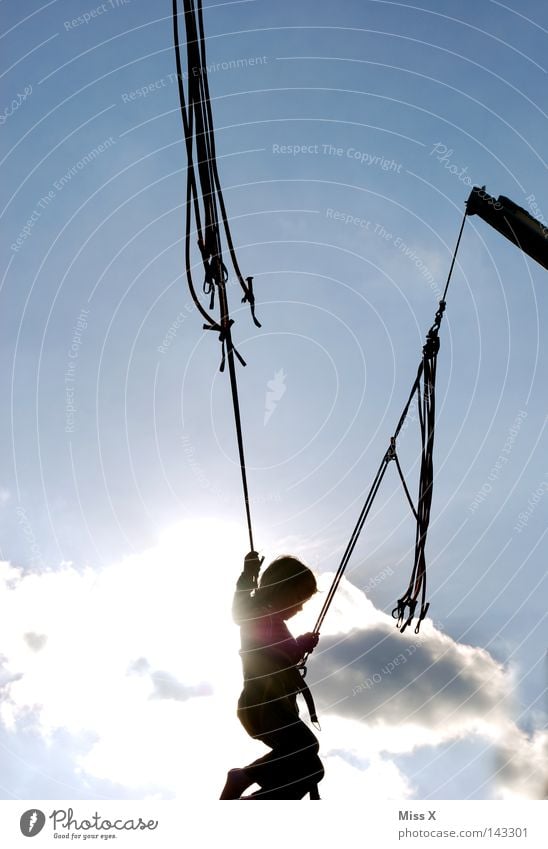 jump Colour photo Exterior shot Day Light Shadow Silhouette Sunbeam Joy Summer Feasts & Celebrations Fairs & Carnivals Rope Aviation Infancy Clouds