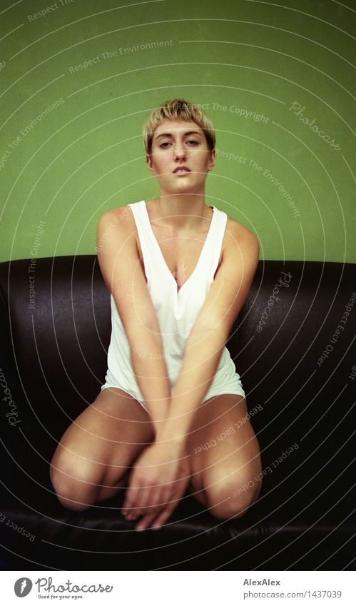 Analog portrait (35mm) of a young, slim, athletic woman sitting on a couch in her underwear and looking at the camera Relaxation Calm Young woman