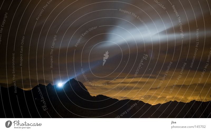 Light in the night Lighting Floodlight Illuminate Long exposure Sunset Evening Late Evening sun Night Clouds Movement White Blue Orange Mountain Silhouette