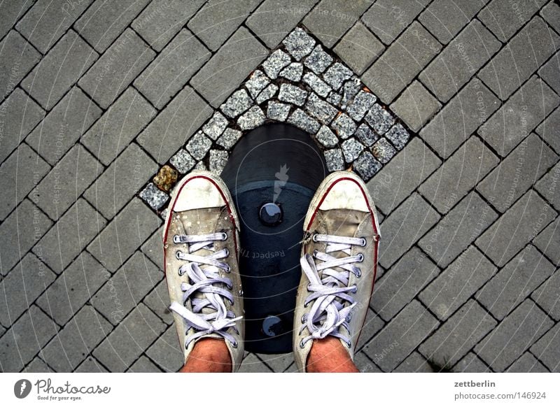 pile standing Street Traffic lane Sidewalk Cobbled pathway Pave Cobblestones Paving stone Bollard Pole Wooden stake Border Boundary Shadow Human being Stand