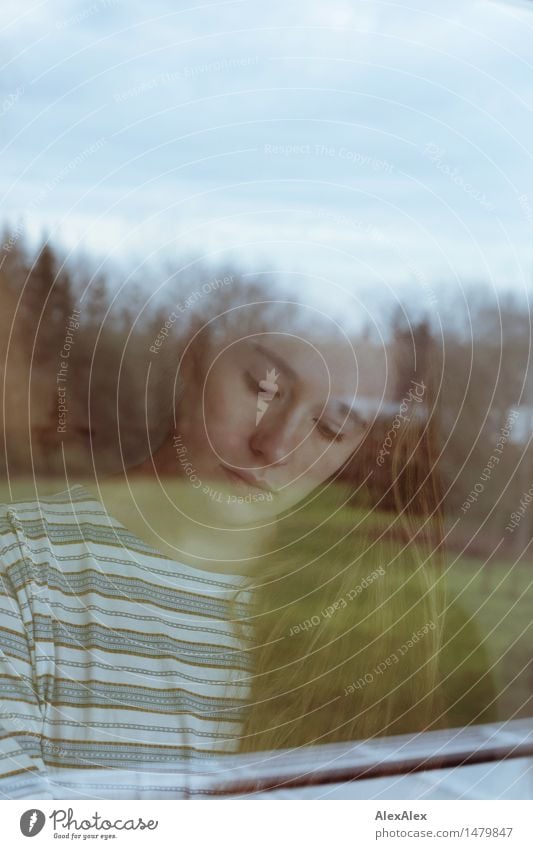 Young woman calmly looking down through a window pane Flat (apartment) Garden Window pane Youth (Young adults) Face 18 - 30 years Adults Landscape