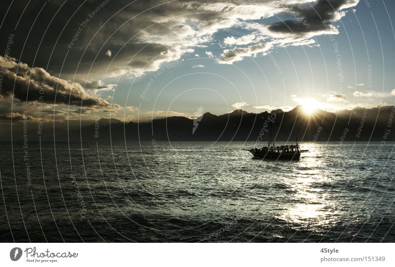 On the way to the horizon Ocean Clouds Mountain Sunset Watercraft Sunrise Dark Threat Bad weather Lake