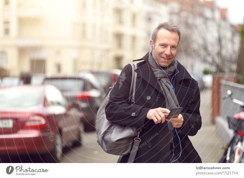 Attractive man in winter fashion checking his mobile Winter Business To talk Telephone Technology Masculine Man Adults 1 Human being 30 - 45 years Street