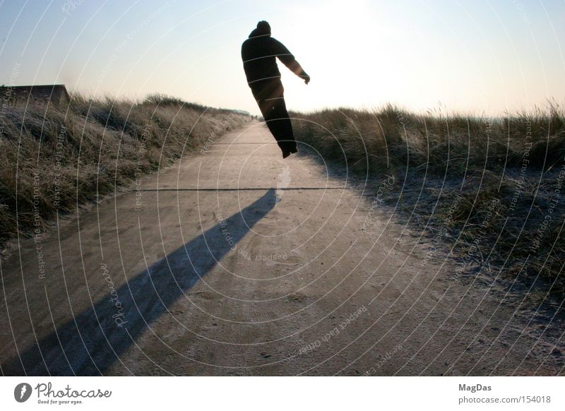 jumpie Winter Cold Ice Movement Sky Shadow Sun Jump Man Freedom Exterior shot Island Beach dune Energy industry