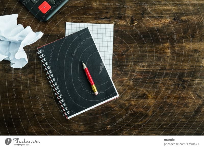 a red pencil on a black notebook, a plaid piece of paper, a white crumpled sheet with a red "+" on an old desk School Professional training Academic studies