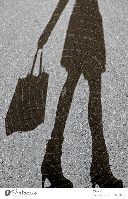 shopping spree Shopping Woman Adults Legs Street Footwear Gray Black Joie de vivre (Vitality) Asphalt Stony In transit Shadow play Gravel Paper bag Consumption