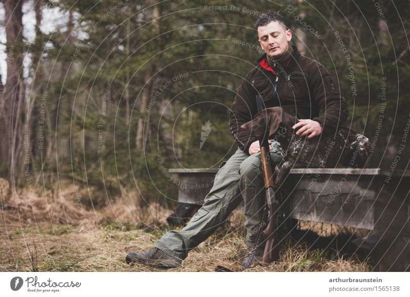 Young hunter with rifle and his hunting dog in front of a hunting lodge in the forest Leisure and hobbies Hunting Trip Hiking To go for a walk Human being