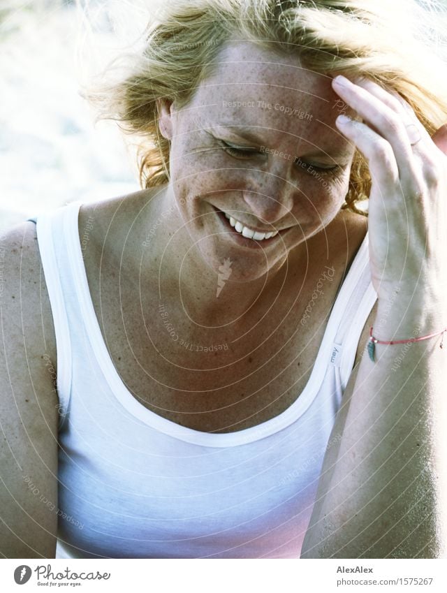 Young blonde woman with dimples and freckles smiles and holds hand to her forehead Life Well-being Trip Summer Summer vacation Sun Beach Young woman