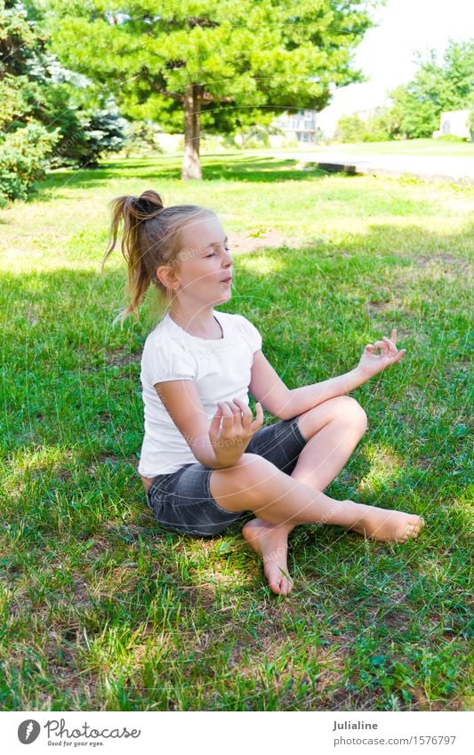 Cute girl are sitting on green grass Summer Yoga Child Schoolchild Girl Infancy 8 - 13 years Grass Blonde Blue Green White Lotus pose kid preschooler six 7