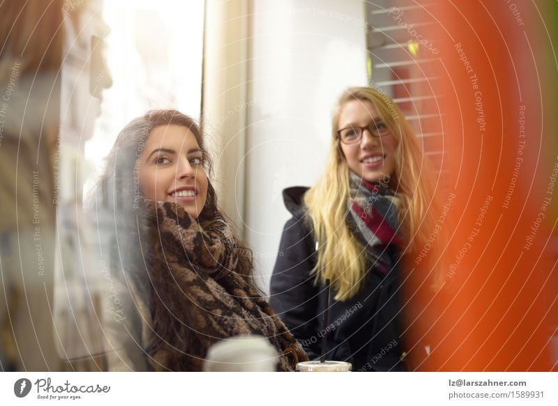 Female friends talking in a public space Happy Calm Winter To talk Woman Adults Friendship 3 Human being 18 - 30 years Youth (Young adults) Small Town