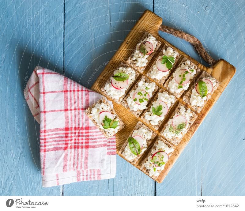 Crispbread with cottage cheese radishes and herbs Herbs and spices Wood Blue Radish Cream cheese Chives Dill Parsley beetroot leaves Wooden board Snack