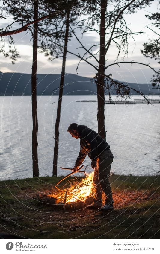 Man lights a fire in the fireplace in nature at night Leisure and hobbies Vacation & Travel Tourism Adventure Camping Summer Mountain Hiking Human being Adults