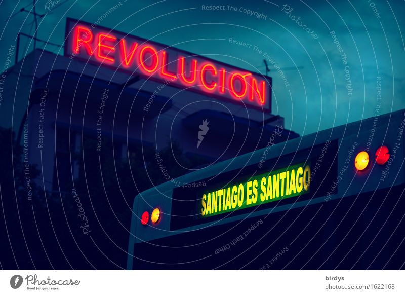 Neon sign " revolucion " on a building in Santiago de Cuba. In the foreground a bus with the neon sign " Santiago es Santiago " a statement by Fidel Castro about the particularity of Santiago de Cuba.