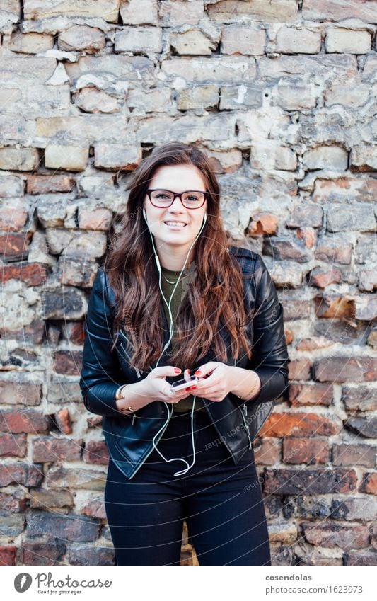 Young woman with smartphone in hand listening to music Lifestyle Leisure and hobbies University & College student Feminine Youth (Young adults) 18 - 30 years