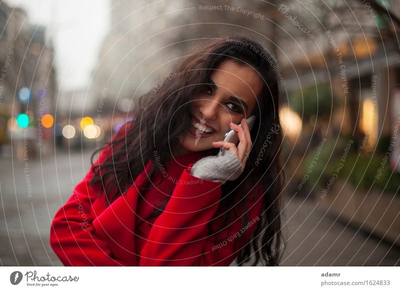 Beautiful Smiling Woman in red coat with mobile phone in hands, smartphone, urban scene woman smile smiling lifestyle girl person cold winter female technology