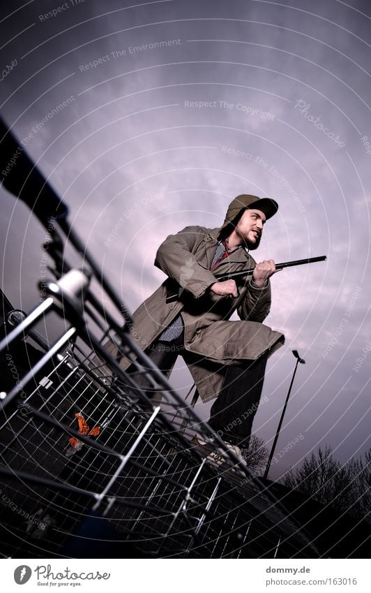 wild joe goes big city Man Hunter Weapon Shotgun Shopping Trolley Cap Dangerous Threat Large Grinning Facial hair Fear Panic Playing trench coat