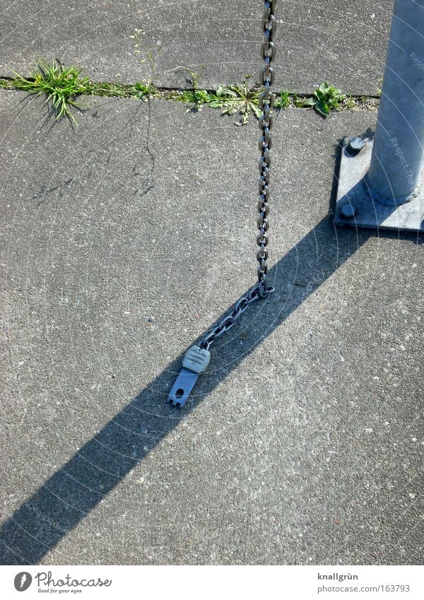 Shopping trolley fastening chain Subdued colour Exterior shot Deserted Copy Space left Light Shadow Concrete Metal Gray Green Silver Drop shadow 12 noon Chain