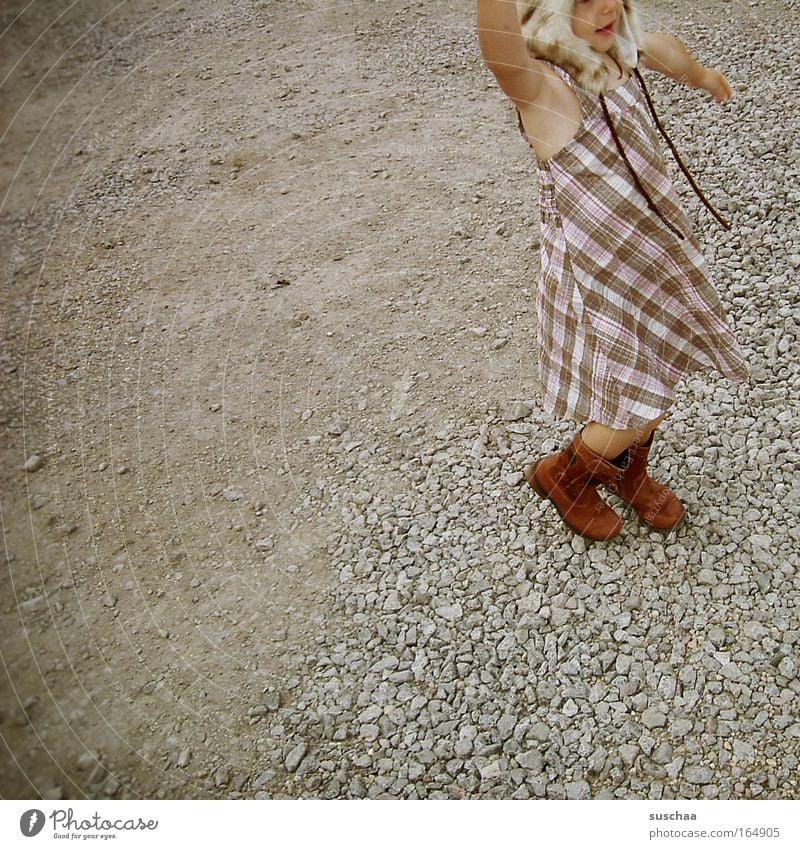 cap wearer Subdued colour Exterior shot Copy Space left Full-length Half-profile Looking away Child Girl Infancy 3 - 8 years Dress Boots Cap Headwear Movement