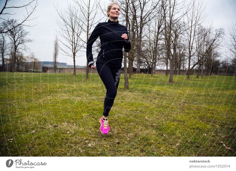 blonde woman running in park Lifestyle Body Wellness Winter Sports Jogging Human being Woman Adults Grass Park Movement Fitness Athletic Speed Practice healthy