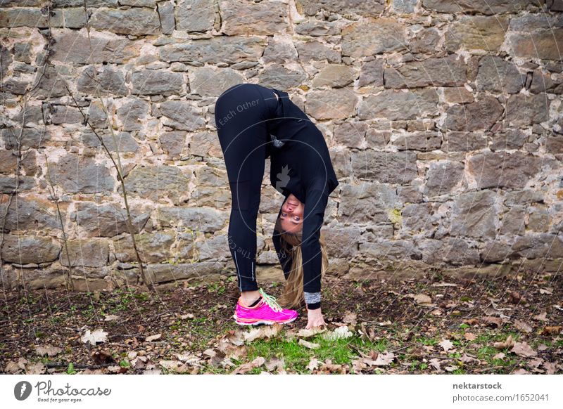 Woman stretching her body in front of ancient wall in park Lifestyle Happy Body Wellness Sports Human being Adults Park Stone Fitness Smiling Athletic