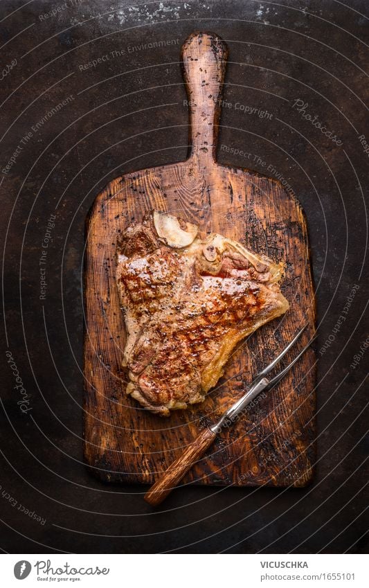 T- bone steak with meat fork on old cutting board Food Meat Nutrition Dinner Buffet Brunch Picnic Organic produce Fork Style Design Restaurant Steak Steakhouse