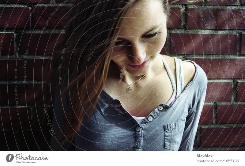 young woman leans against a brick wall and looks down luck Young woman Youth (Young adults) Head Face Freckles 18 - 30 years Adults Beautiful weather