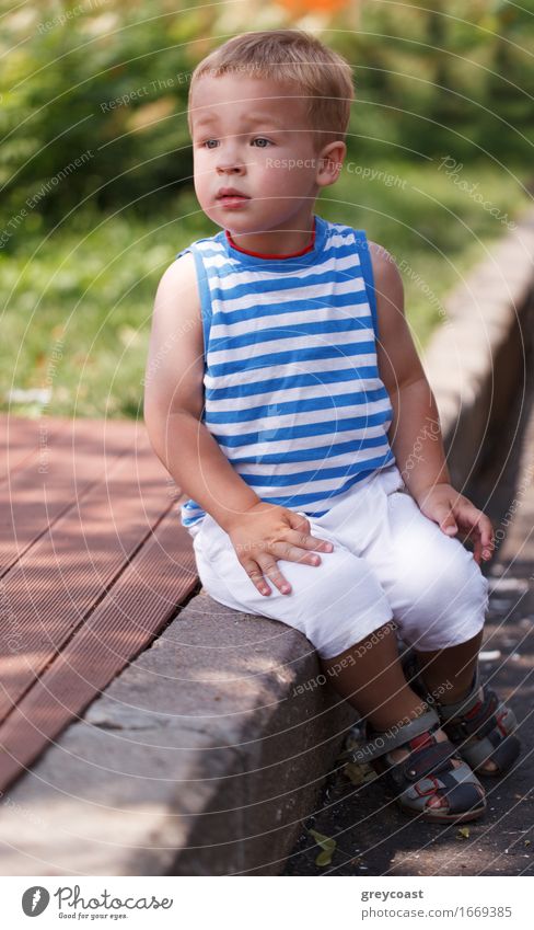 Portrait of a three year-old boy sitting on the curb and looking left Lifestyle Face Summer Child Human being Baby Toddler Boy (child) Infancy 1 1 - 3 years