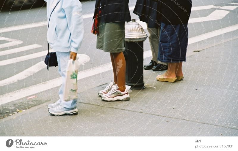 legs Footwear Dark Fire hydrant Bus stop Sidewalk Group Legs Bright Human being Street Wait Queue