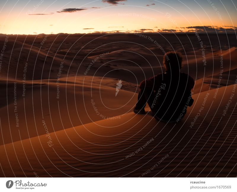 Man sitting on a dune in the desert while watching the sunset Beautiful Relaxation Meditation Vacation & Travel Tourism Trip Adventure Freedom Summer