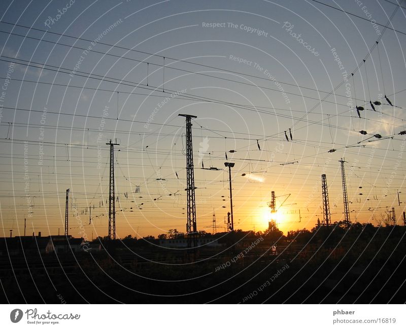 Track view Weststadt Cafe Overhead line Electricity Railroad tracks Across Sunset Yellow Back-light Mushroom cloud Transport Electricity pylon Energy industry