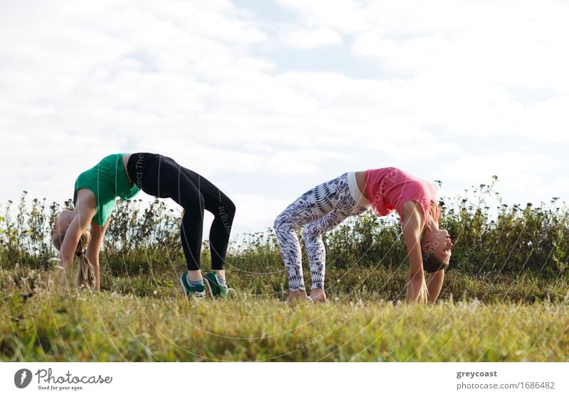 Two young girls training together outdoors: stretching exercises Summer Garden Human being Girl Young woman Youth (Young adults) Woman Adults 2 18 - 30 years