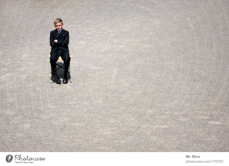 sit-down strike Exterior shot Boy (child) Cool (slang) Sit Chair Get stuck Wait sit around cross arms Boredom Loneliness Suit Serene Contentment Posture Seating