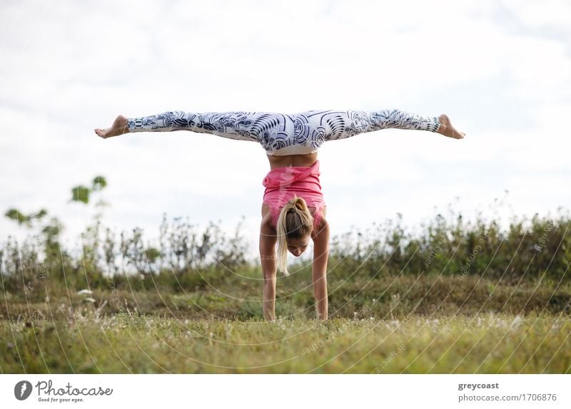 Young girl training outdoors: suppling exercises standing on hands. Summer Sports Fitness Sports Training Human being Girl Young woman Youth (Young adults)