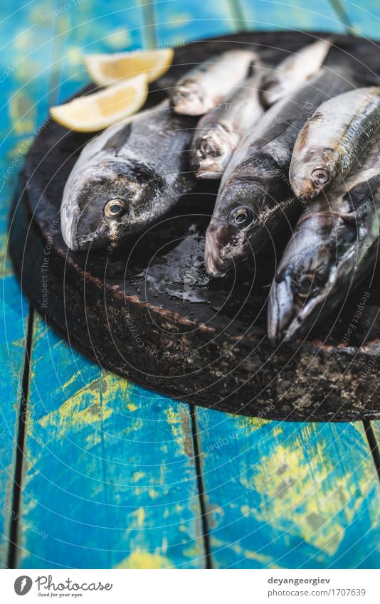 Raw fish. Sea bream, sea bass, mackerel and sardines Seafood Lunch Pan Fresh Blue Black see bass Lemon cooking background healthy Frying Fat Mackerel head