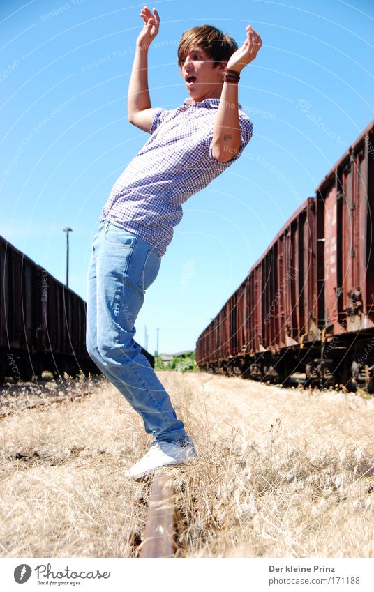 The astonished young man in front of old goods wagons Copy Space bottom Sunlight Full-length Joy Young man Youth (Young adults) 1 Human being Freight train