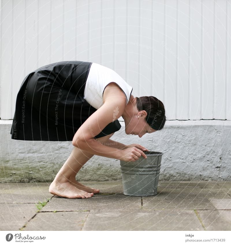 Woman in a dress looks into a metal bucket Lifestyle Elegant Style Leisure and hobbies Adults Body 1 Human being 30 - 45 years Wall (barrier) Wall (building)