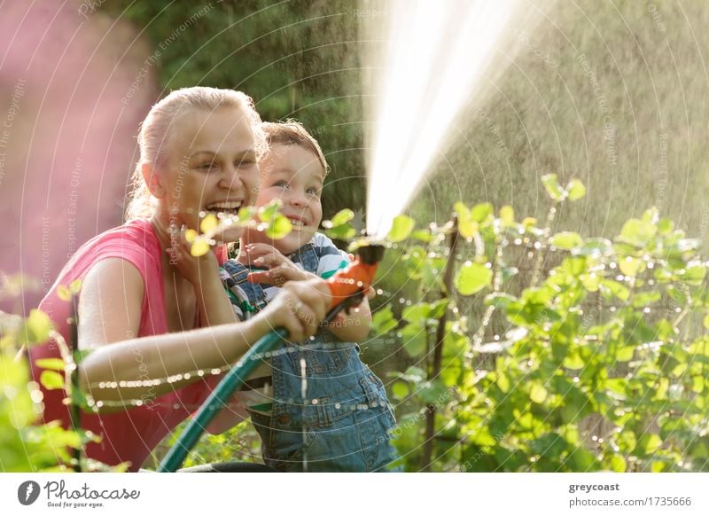 Young mother and cute son playing with water hose in the garden Joy Happy Playing Summer Garden Child Boy (child) Mother Adults Family & Relations 2 Human being