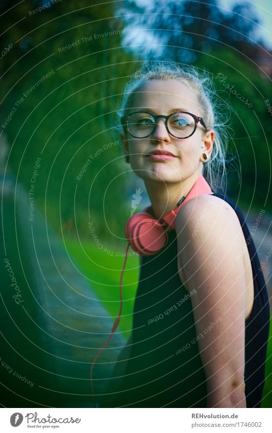 A young woman leans against a wall Upper body portrait Central perspective Shallow depth of field blurriness Day Exterior shot Colour photo Hipster Future