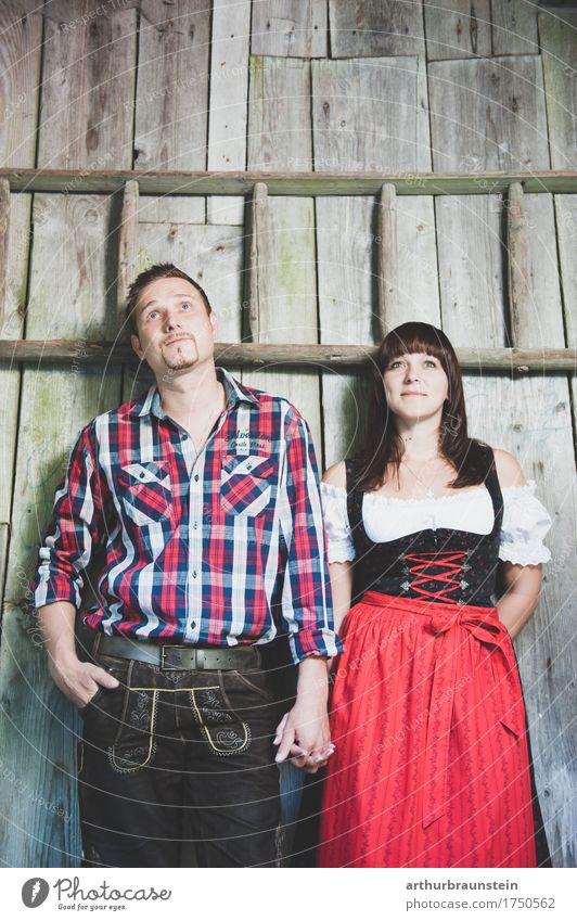 Young couple in front of a wooden hut in traditional costume Lifestyle Tourism Trip Oktoberfest Fairs & Carnivals Human being Masculine Feminine Young woman