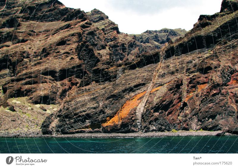 Colourful giants Colour photo Exterior shot Deserted Nature Landscape Earth Rock Volcano Coast Bay Ocean Stone Water Old Threat Firm Gigantic Large Blue Brown