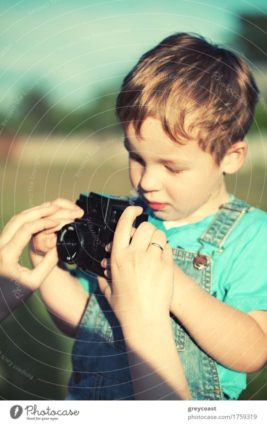 Mother helping her little son to take his first pictures outdoor. Focus on mothers hands. Instagram style color toned Summer Child Camera Boy (child) Adults