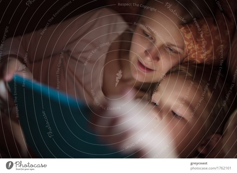 Mother and little son watching video or playing on touchpad lying in bed at night Playing Child Computer Boy (child) Young woman Youth (Young adults) Adults