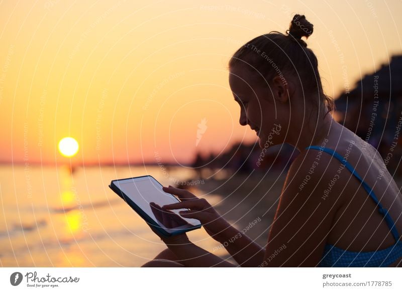 Happy young woman with tablet PC on beach at sunset. Evening sun, sea and beach on background Vacation & Travel Summer Sun Beach Ocean Computer Girl Young woman