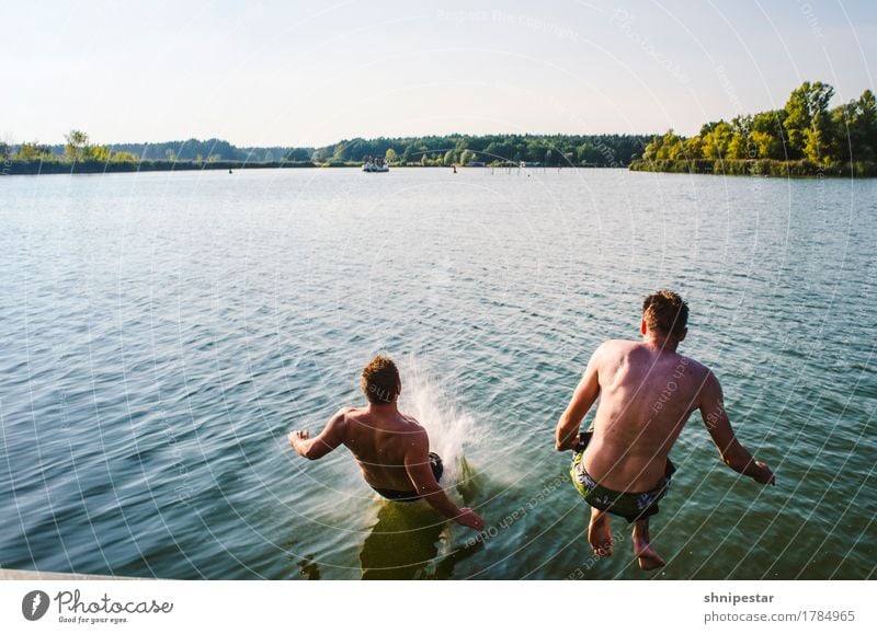 Two young men jump into the water Joy Athletic Fitness Well-being Vacation & Travel Adventure Summer Sun Sports Sports Training Swimming & Bathing Human being