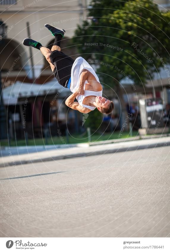 Young sportsman performing his acrobatic skills in doing somersault. Show in the city street Lifestyle Summer Sports Human being Man Adults Town Street Movement