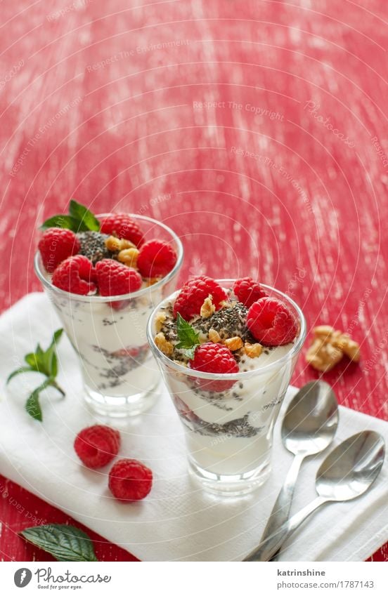 Breakfast with Yogurt and raspberries Yoghurt Fruit Dessert Nutrition Vegetarian diet Diet Spoon Wood Fresh Delicious Green Red White Berries cream Dairy food